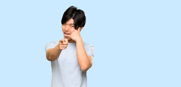 Asian Man Blue Shirt Making Phone Gesture Pointing Front Isolated — 스톡 사진