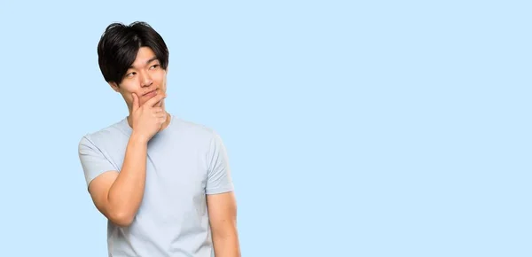 Asian Man Blue Shirt Thinking Isolated Blue Background — 스톡 사진