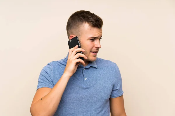 Joven hombre rubio utilizando el teléfono móvil —  Fotos de Stock