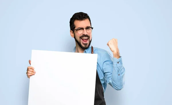 Hombre con delantal sosteniendo un cartel vacío —  Fotos de Stock