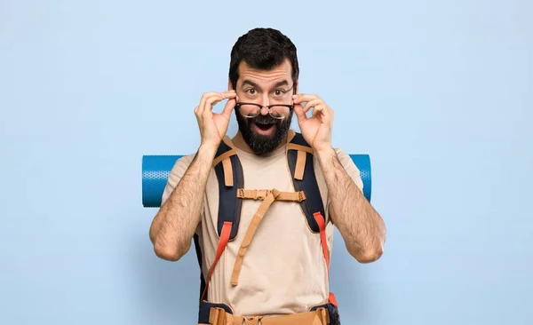 Turista Muž Brýlemi Překvapen Přes Izolované Modré Pozadí — Stock fotografie