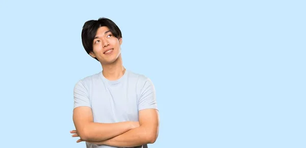 Asian Man Blue Shirt Looking While Smiling Isolated Blue Background — Stock Photo, Image