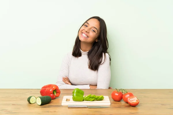 Young brunette woman with vegetables laughing