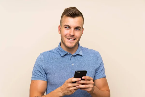 Happy Young blonde man using mobile phone — Stock Photo, Image