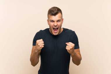 Izole arka plan üzerinde genç yakışıklı sarışın adam kötü bir durum tarafından sinirli