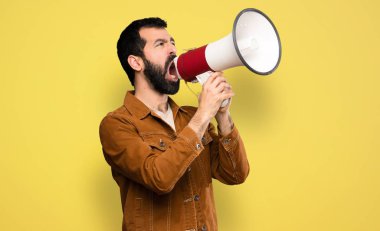Handsome man with beard shouting through a megaphone