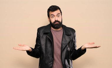 Handsome man with beard having doubts while raising hands
