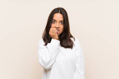 Young brunette woman with white sweater over isolated background nervous and scared