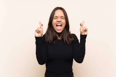 İzole edilmiş arka planda beyaz kazaklı esmer bir kadın.