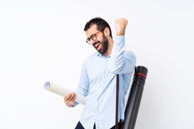 Young architect man with beard over isolated white background celebrating a victory