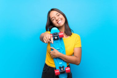 Izole mavi arka plan üzerinde genç patenci kadın