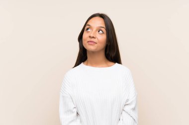 Young brunette woman with white sweater over isolated background laughing and looking up