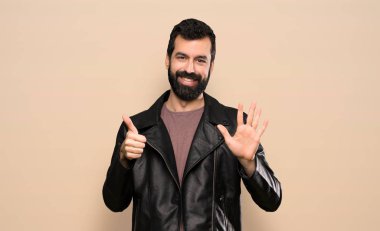 Handsome man with beard counting six with fingers