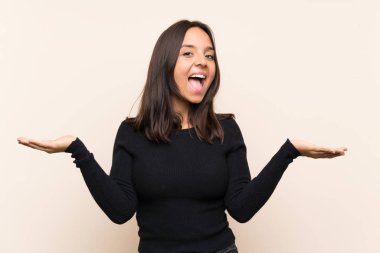 Young brunette woman with white sweater over isolated background with shocked facial expression