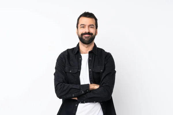 Young man with beard over isolated white background keeping the arms crossed in frontal position
