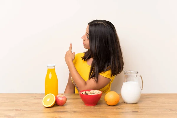 Junges Brünettes Mädchen Frühstückt Milch Und Zeigt Mit Dem Zeigefinger — Stockfoto