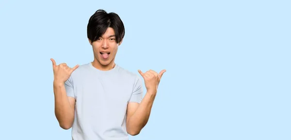 Asian Man Blue Shirt Making Rock Gesture Isolated Blue Background — 스톡 사진