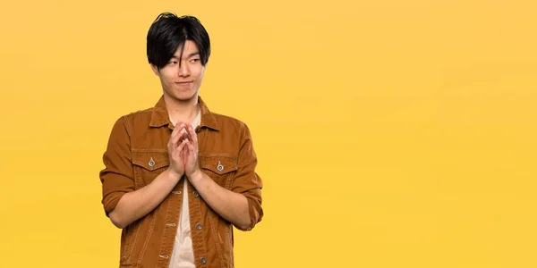 Asiatischer Mann Mit Brauner Jacke Intrigiert Etwas Über Isoliertem Gelben — Stockfoto