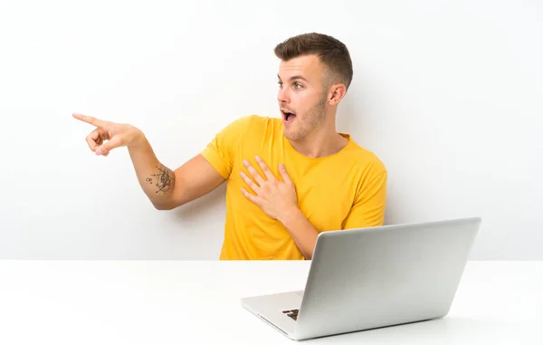 Jonge Blonde Man Een Tafel Met Een Laptop Wijzend Vinger — Stockfoto