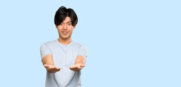 Aziatische Man Met Blauw Shirt Houden Copyspace Imaginaire Palm Een — Stockfoto