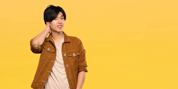 Asiatischer Mann Mit Brauner Jacke Zweifelt Isoliertem Gelben Hintergrund — Stockfoto