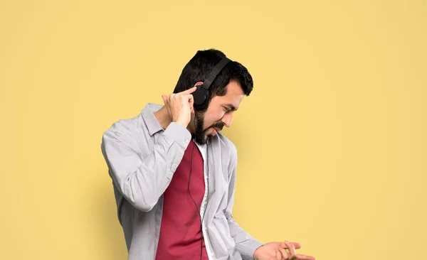 Stilig man med skägg lyssnar musik — Stockfoto
