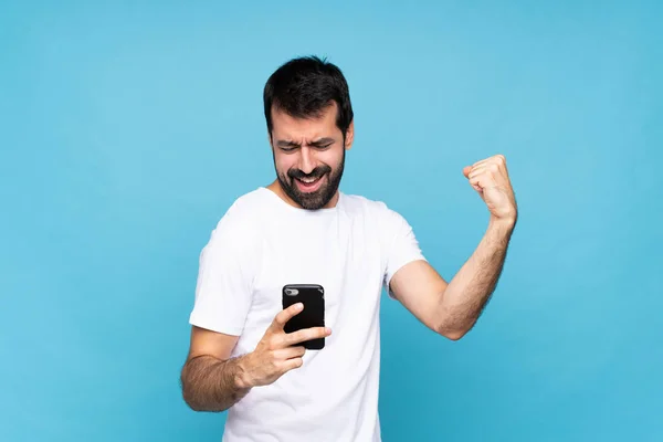 Young Man Beard Isolated Blue Background Phone Victory Position — Stock Photo, Image