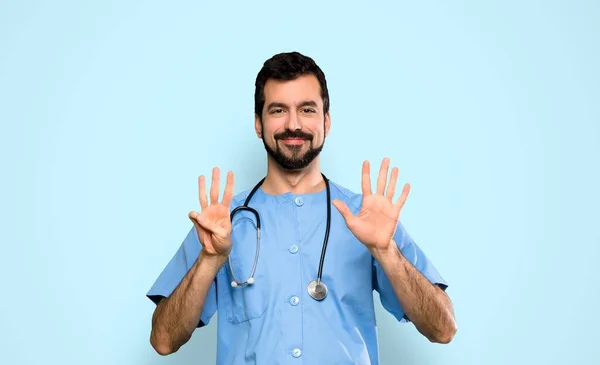 Cirurgião Médico Homem Contando Oito Com Dedos Sobre Fundo Azul — Fotografia de Stock