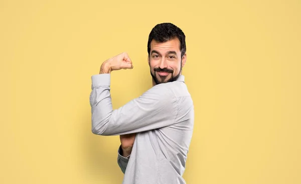 Knappe Man Met Baard Doet Sterk Gebaar Geïsoleerde Gele Achtergrond — Stockfoto