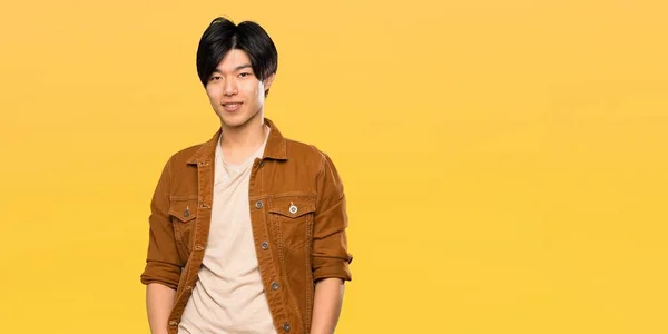 Pria Asia Dengan Jaket Coklat Tertawa Atas Latar Belakang Kuning — Stok Foto