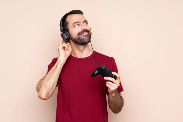 Mann Spielt Mit Einem Videospielcontroller Über Isolierte Wand Und Denkt — Stockfoto