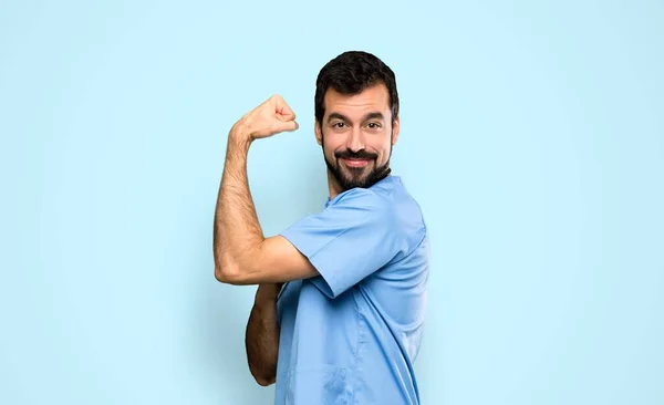 Surgeon Doctor Man Doing Strong Gesture Isolated Blue Background — 스톡 사진