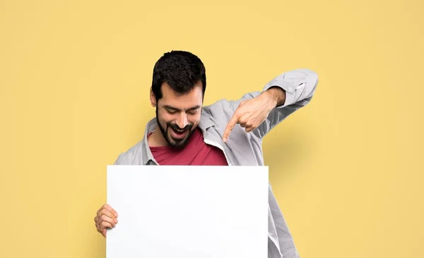 Schöner Mann mit Bart, der ein leeres Plakat hält — Stockfoto