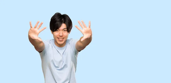 Asian Man Blue Shirt Counting Ten Fingers Isolated Blue Background — 스톡 사진