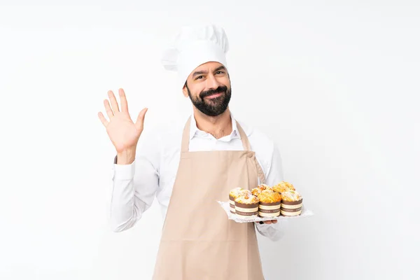 Jovem Segurando Bolo Muffin Sobre Fundo Branco Isolado Saudando Com — Fotografia de Stock