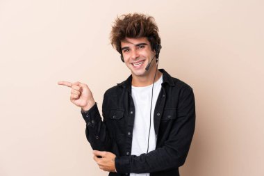 Tele pazarlamacı arka planda kulaklıkla çalışıyor.