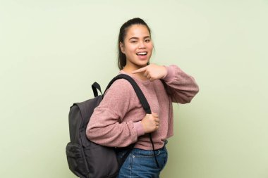 Sırt çantası ile izole yeşil arka plan üzerinde Genç genç Asyalı kız