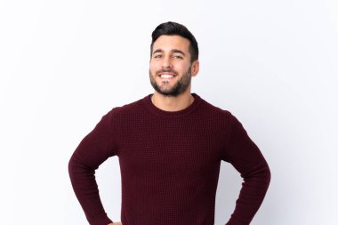 Sakallı yakışıklı bir genç soyutlanmış beyaz bir geçmişi var. Kolları kalçasında ve gülümsüyor.