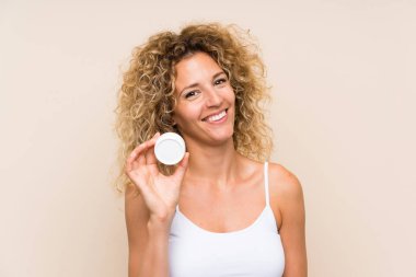 Nemlendirici ile kıvırcık saçlı genç sarışın kadın