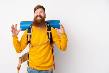 Genç dağcı, izole edilmiş beyaz arka planda büyük bir sırt çantası ile gülüyor.