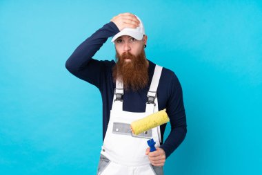 Uzun sakallı ressam, mavi arka planda, şaşırmış bir yüz ifadesi var.