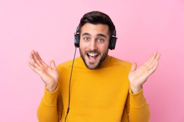 Sakallı yakışıklı genç adam soyutlanmış pembe müzik dinliyor.