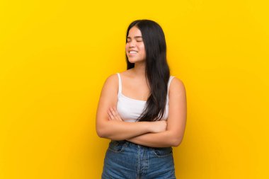 Young teenager Asian girl over isolated yellow background happy and smiling