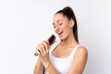 Saçları taranmış, şarkı söyleyen, soyutlanmış beyaz arka planı olan esmer bir kadın.