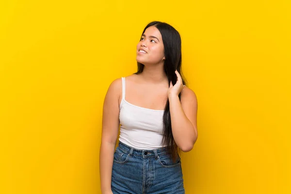 Junge Teenager Asiatische Mädchen Über Isolierte Gelbe Hintergrund Denken Eine — Stockfoto