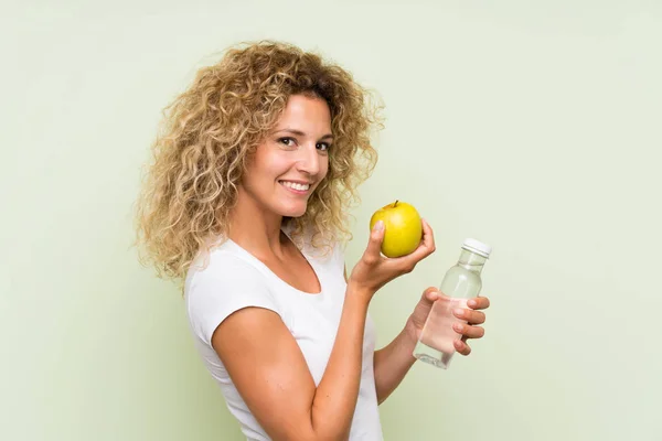 젊은 금발의 여자 와 곱슬 머리 와 a 사과 과 a 병 의 물 — 스톡 사진