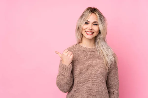 Chica Rubia Adolescente Con Suéter Sobre Fondo Rosa Aislado Apuntando — Foto de Stock