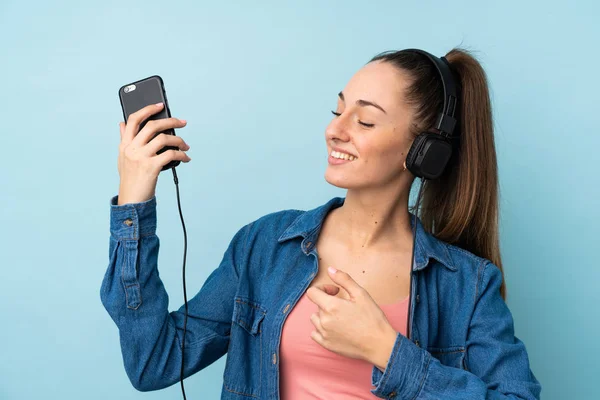 Giovane Donna Bruna Sfondo Blu Isolato Ascoltare Musica Fare Gesto — Foto Stock