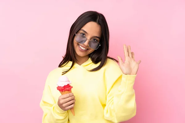 Jovem Morena Segurando Sorvete Corneto Sobre Fundo Rosa Isolado Saudando — Fotografia de Stock