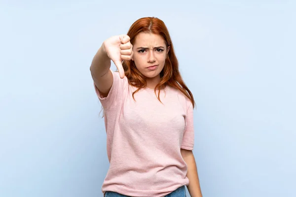 Adolescente Rossa Ragazza Isolato Sfondo Blu Mostrando Pollice Verso Basso — Foto Stock